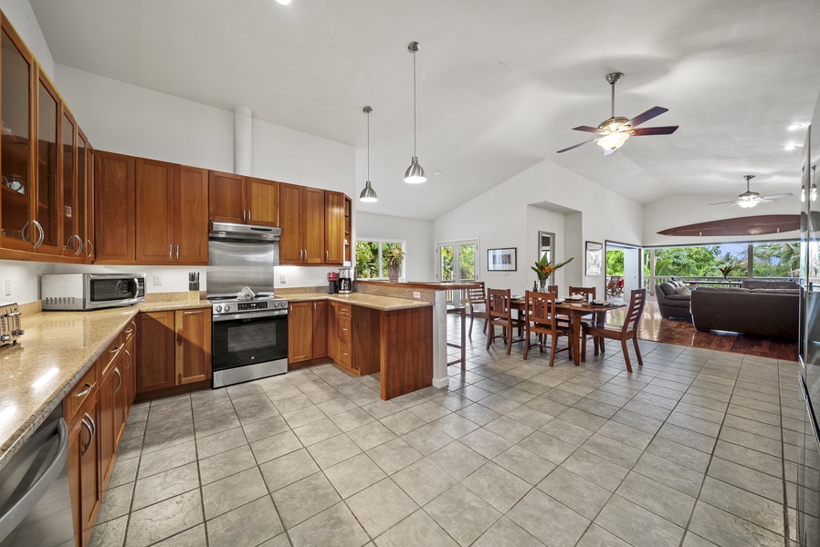 Expansive living room with multiple seating areas, ceiling fans, and garden views.