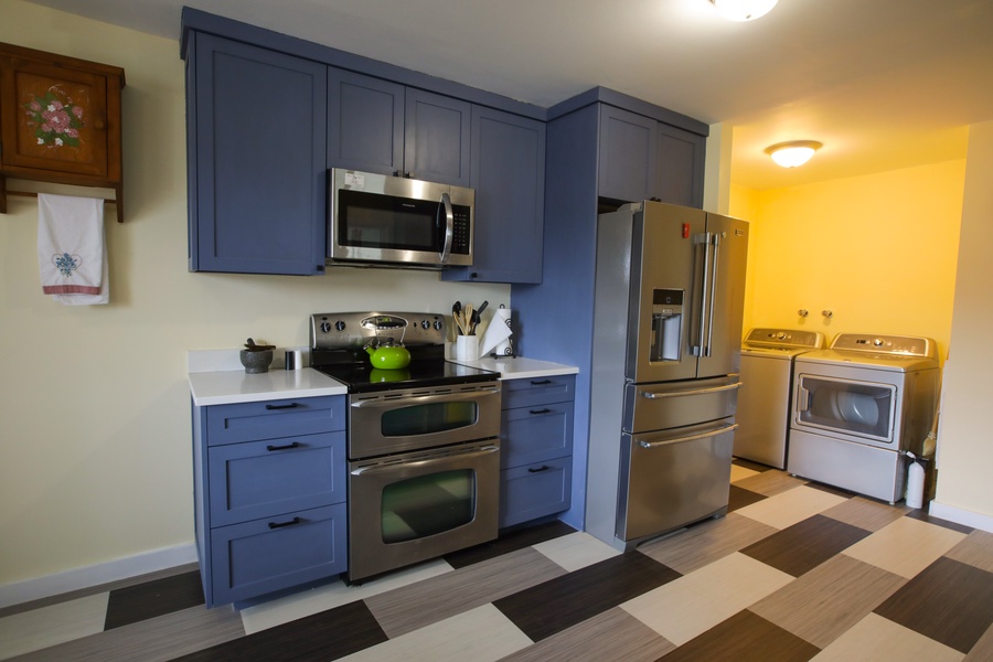Sleek gas range and spacious two-door fridge complete this classic kitchen