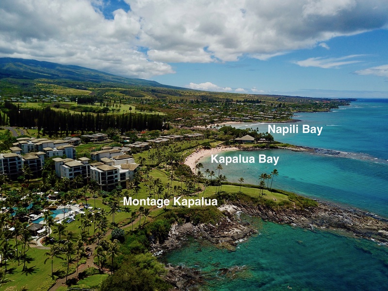 This aerial view captures the scenic beauty of Kapalua Bay and Napili Bay, with the Montage Kapalua resort nestled along the coastline, providing easy access to the picturesque beaches.