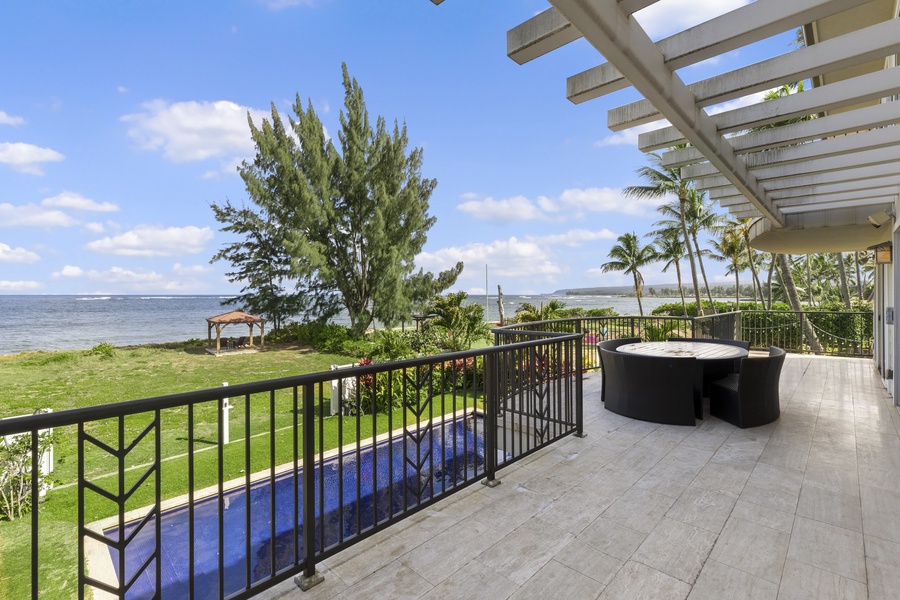 Second-floor entertaining deck with a view of the pool and ocean.