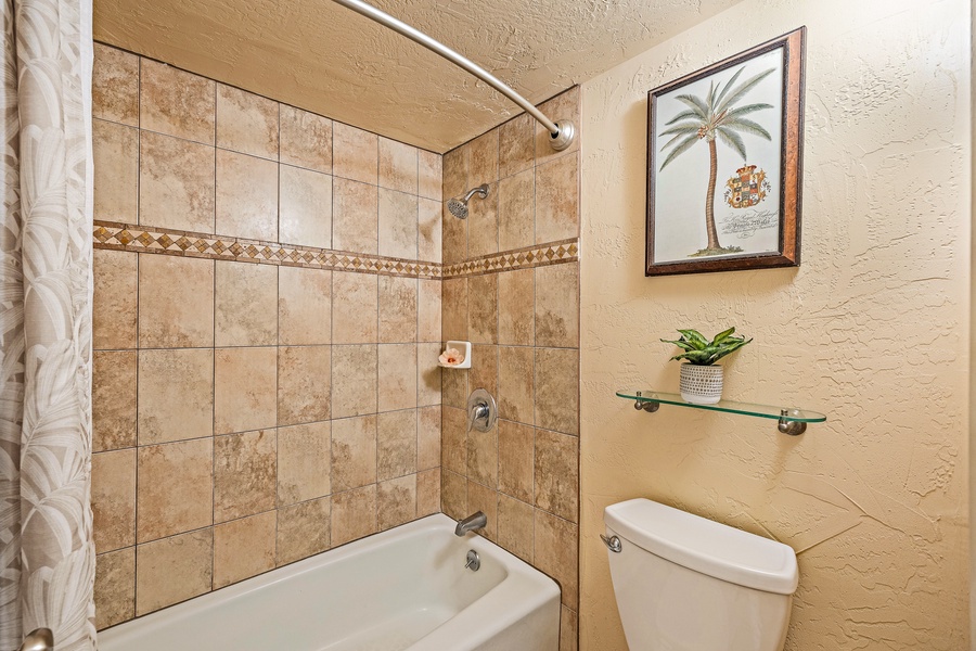 The bathroom includes a tiled shower and tub combination.