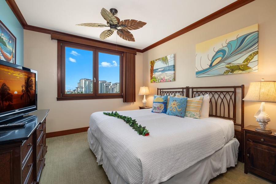 Versatile bedroom with a bed that can convert to twins, tropical-inspired decor, and a view of urban scenery.