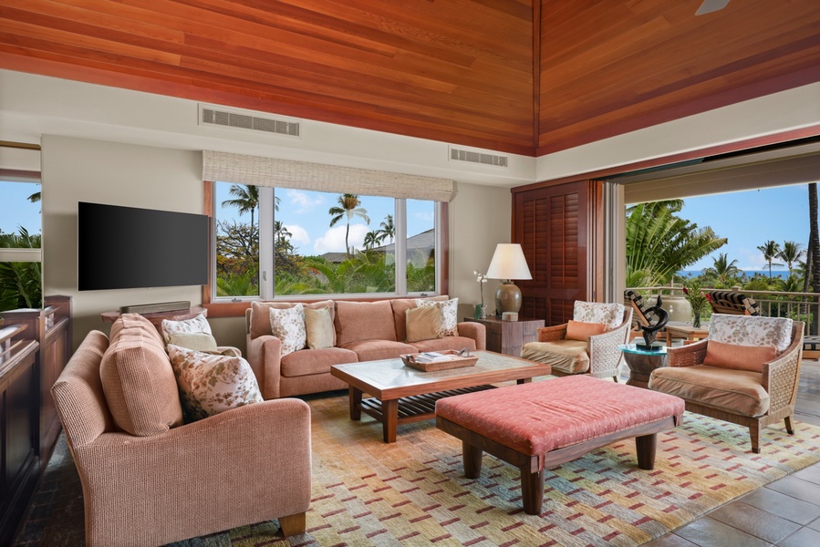 Ample living area plush lounge seating, receding pocket doors to lanai, and formal interior dining area.