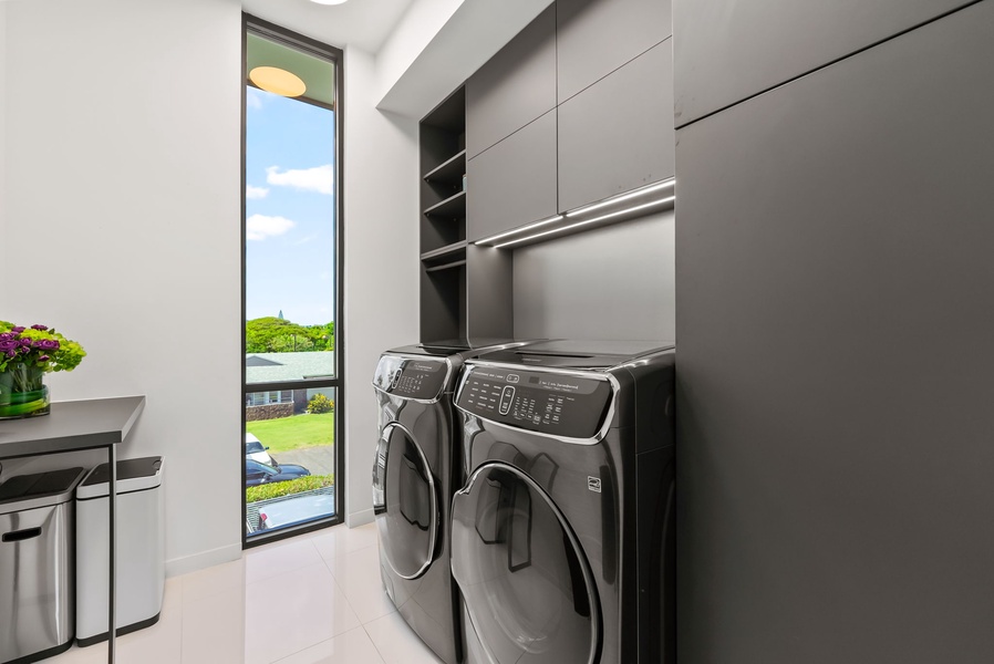 Private laundry with full-size washer and dryer and built-in storage.