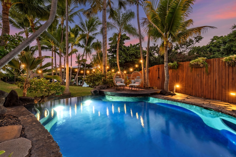 Slip into this illuminated tropical pool as twilight paints the sky in stunning pink hues