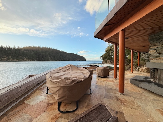 Beautiful outdoor deck with cozy seating, surrounded by nature and waterfront serenity.