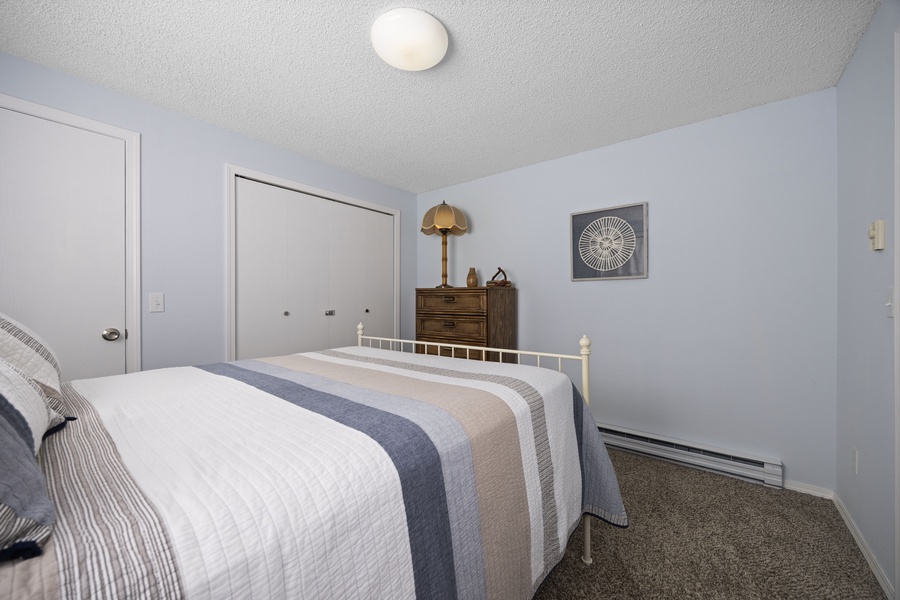The second bedroom also offers soft lighting and dual-closet storage for extended stays.