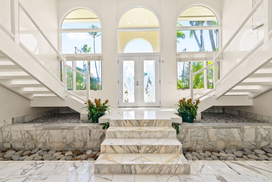 Elegant staircase with expansive windows that frame stunning ocean views, creating a luxurious ambiance.