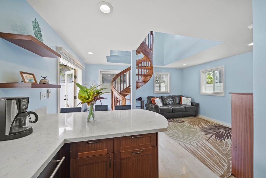 Inside the French doors you walk into a full kitchen with an apartment sized stove and refrigerator, custom cabinetry, and stone countertops.