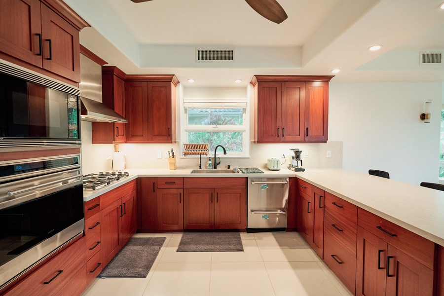 Your spacious kitchen features warm wood cabinets, marble countertops, and professional-grade appliances—perfect for creating memorable meals together.