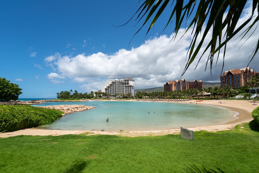 Beautiful tropical lagoon with turquoise waters, palm trees, and luxury resort buildings creating a perfect Hawaiian paradise setting.