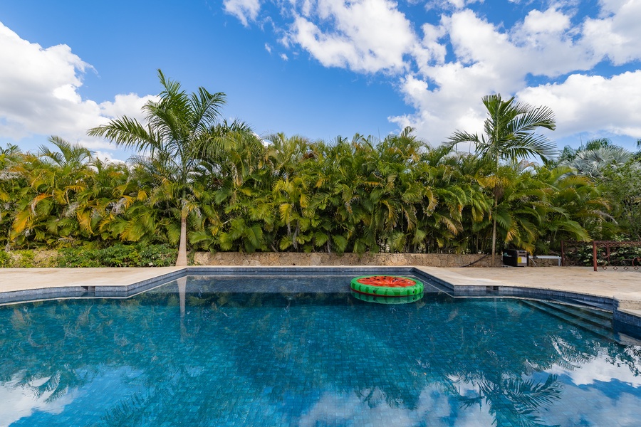Soak in the pool surrounded by lush greenery, providing a serene and refreshing retreat.