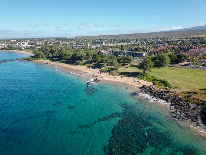 An aerial view of the pristine shoreline, with clear turquoise waters gently meeting the sandy beach