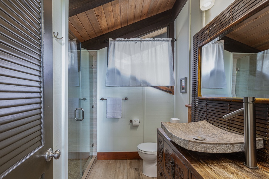 Stylish en-suite with vessel sink, granite vanity, and rainfall shower in the loft suite.