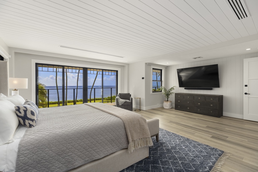 The secondary primary bedroom has a queen bed, lanai with ocean views, and private ensuite with a dual vanity and shower