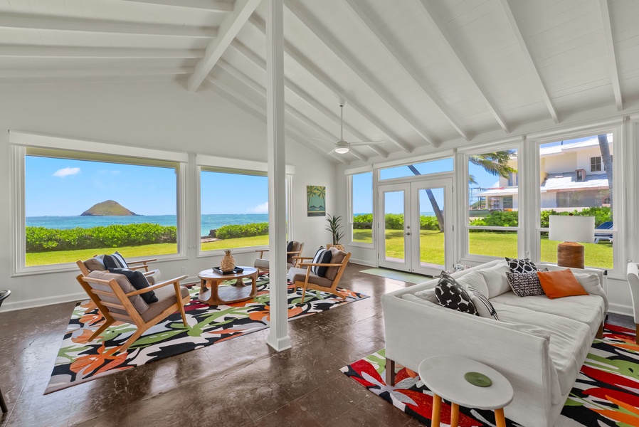 Relax in your bright, open living space with stunning ocean and island views. Watch the waves through floor-to-ceiling windows as you unwind on plush seating, enjoying coastal breezes and tropical scenery.