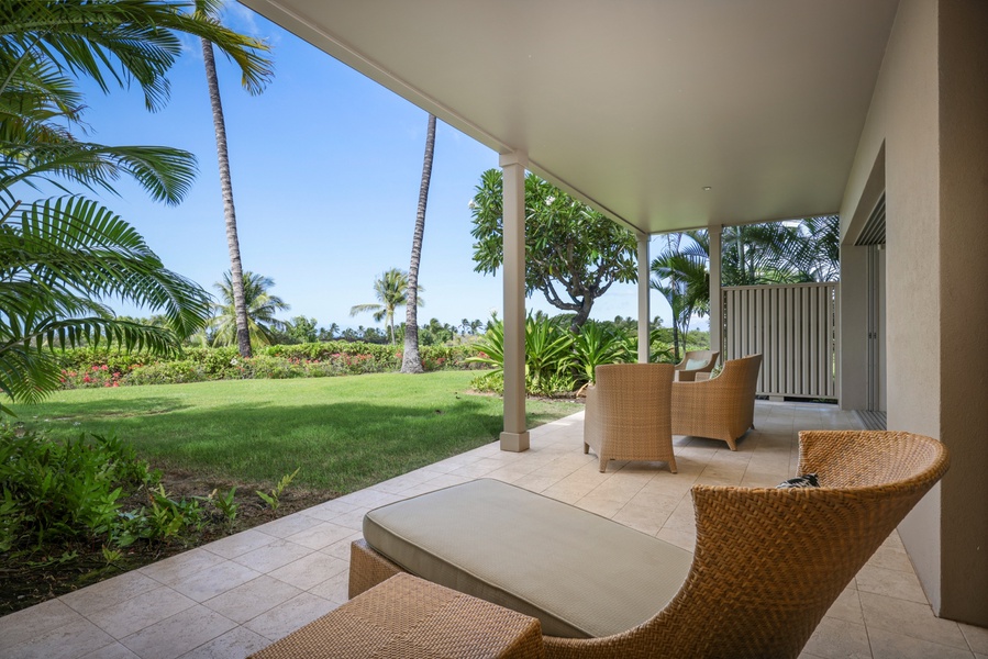 Deck with lounger off primary bedroom suite showcasing expansive grassy lawn.