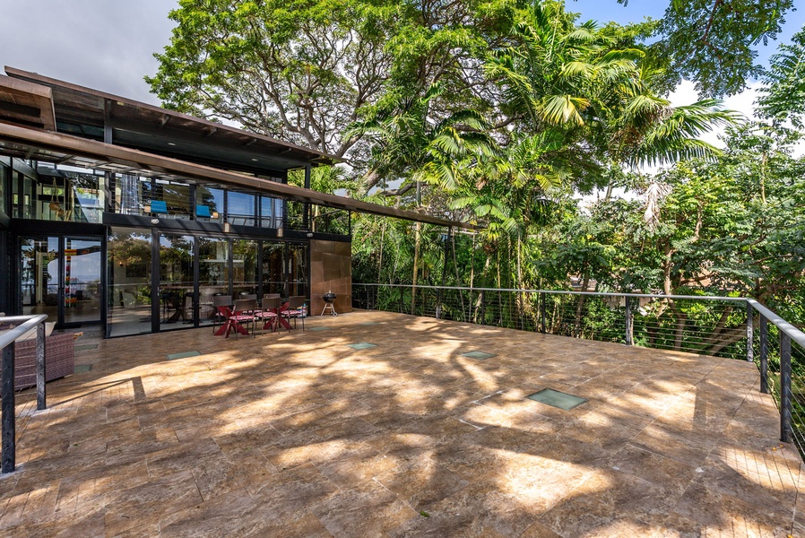 Dine or unwind on this expansive outdoor lanai, surrounded by lush tropical greenery.