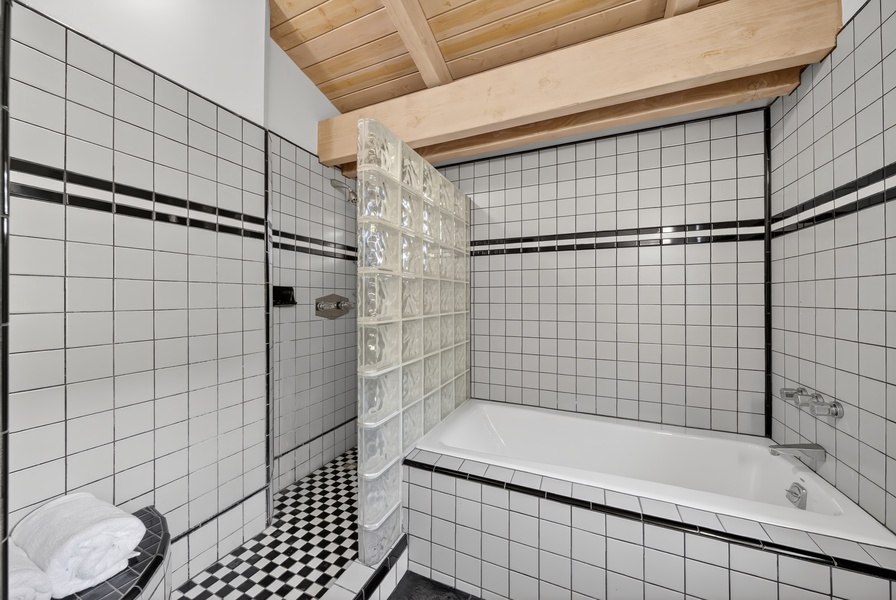 Unwind after beach days in the full bathroom with soaking tub and tiled shower.