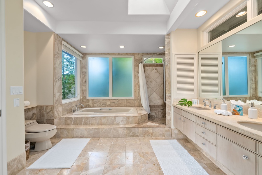 Unwind in your marble sanctuary with a soaking tub, separate shower, and garden views through frosted glass.