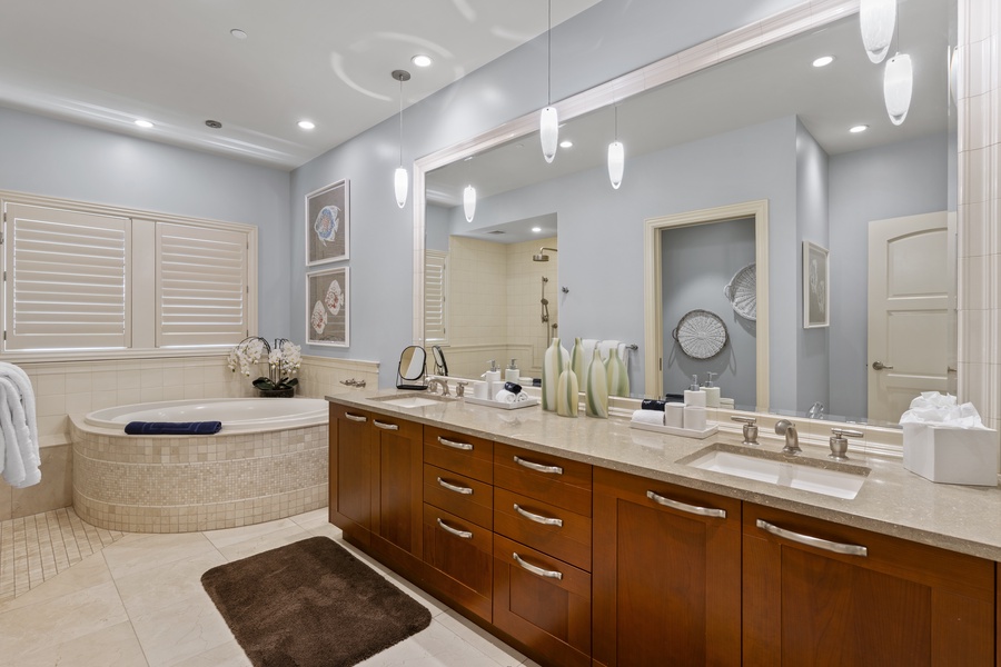 The ensuite bathroom in the primary suite is a luxurious space designed for ultimate relaxation. It features a large soaking tub, perfect for unwinding after a day of island adventures.