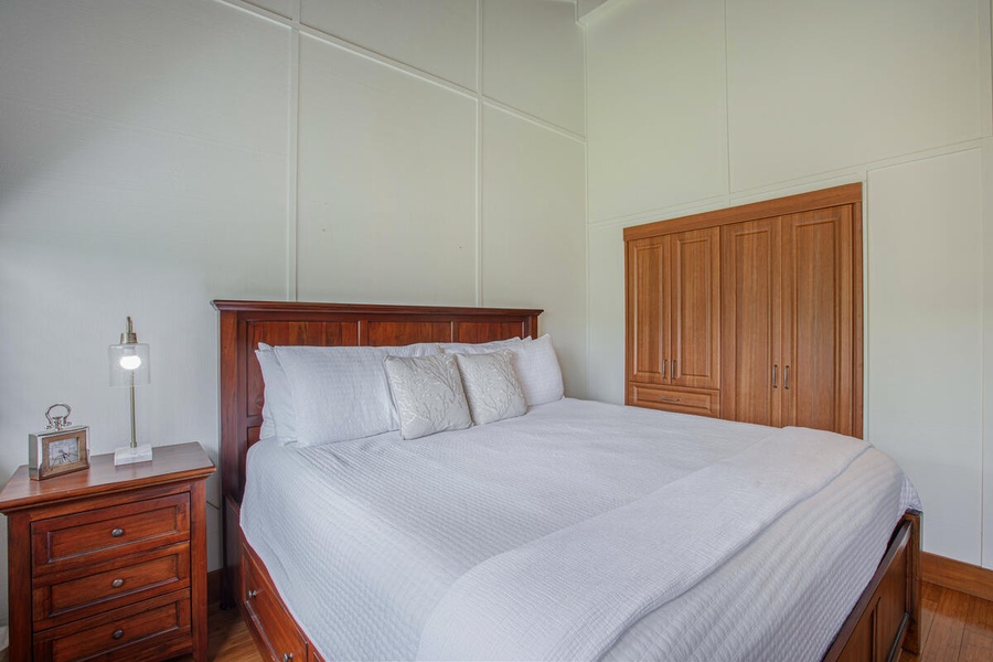 Second primary bedroom with king bed and calming wood tones for restful sleep.