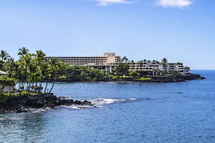 Oceanfront resort nestled along pristine coastline with tropical palm trees and crystal-clear waters.