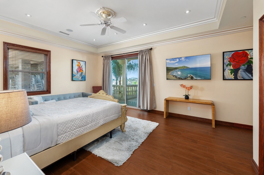 A guest room that keeps it simple: a comfortable bed, warm floors, art on the walls.