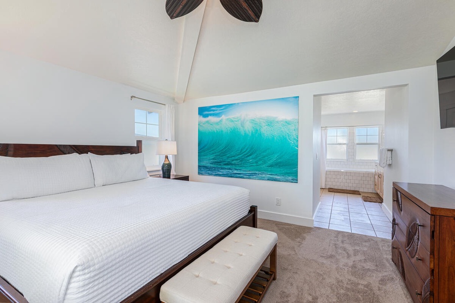 Spacious Leonard bedroom with king bed and tropical art.