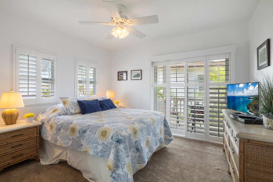 The second guest bedroom with windows to the tropical scenery and a dresser.