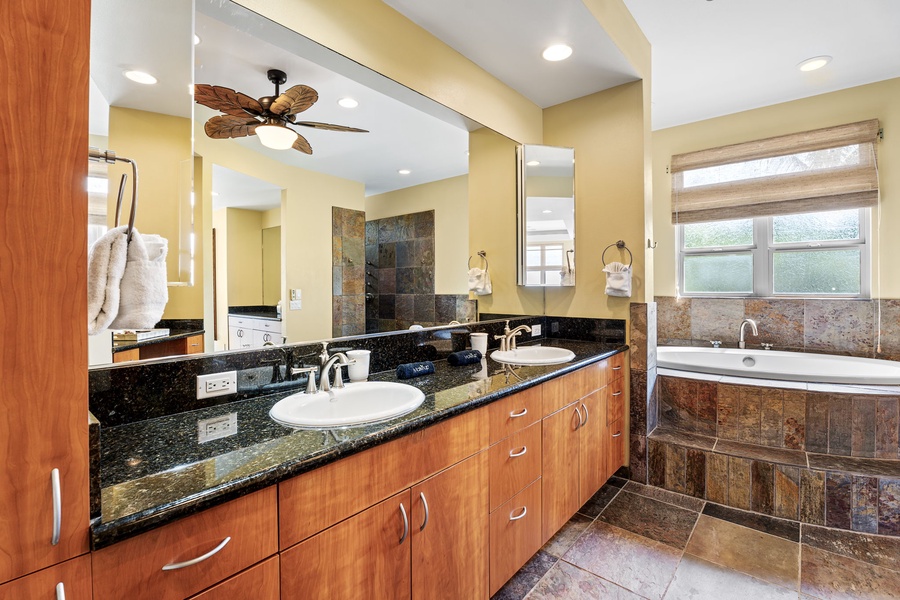 Luxurious bathroom with dual vanities, granite countertops, and a large soaking tub for ultimate relaxation.