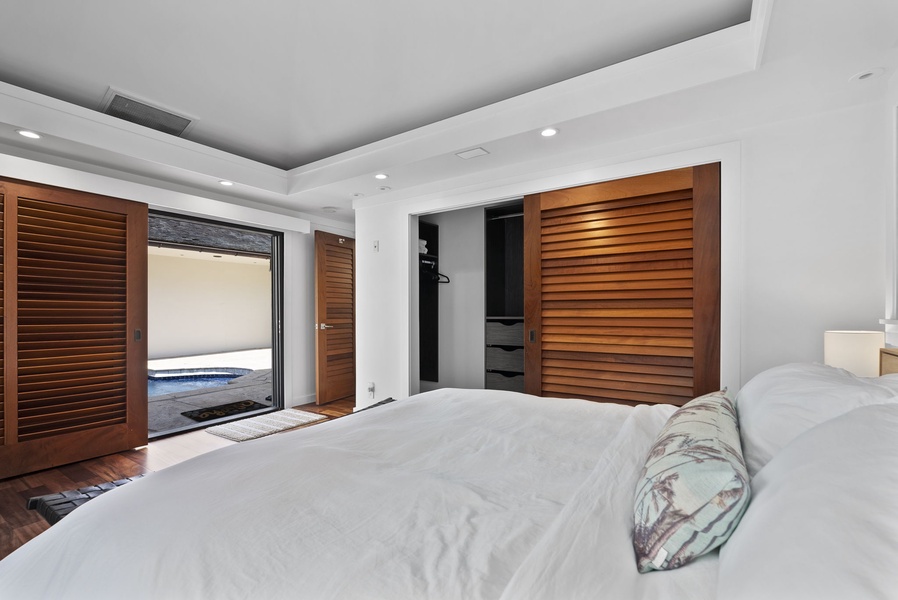 Serene bedroom with wood shutters and easy access to outdoor space.