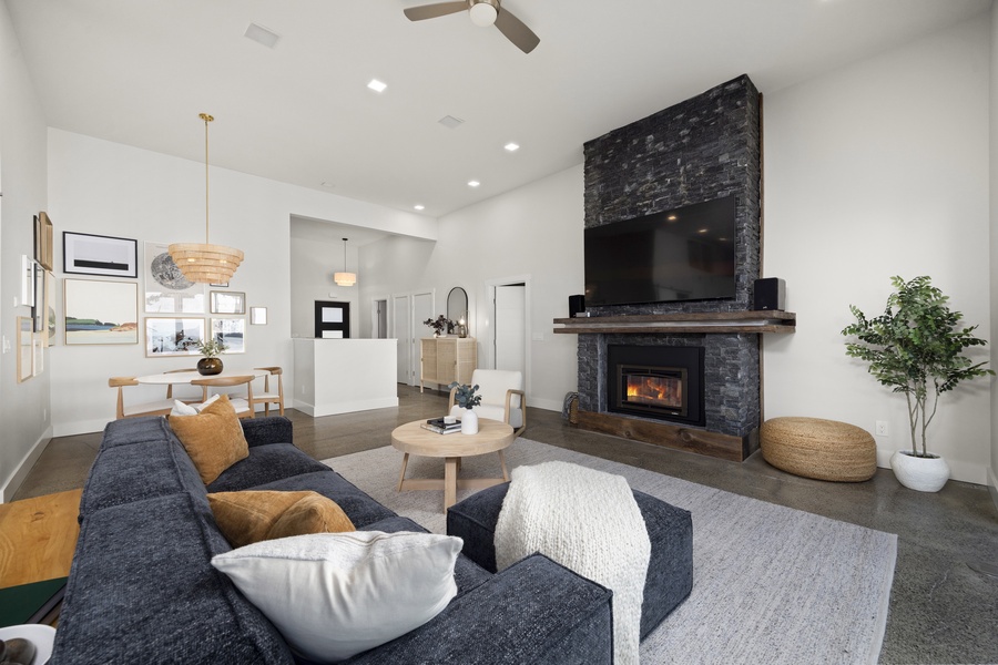 Elegant living space anchored by a stone fireplace and contemporary furnishings — perfect for cozy evenings in.