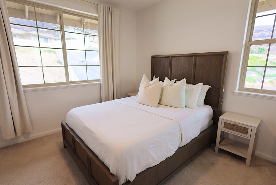 Cozy queen bedroom with soft linens and blackout curtains—perfect for restful island nights.