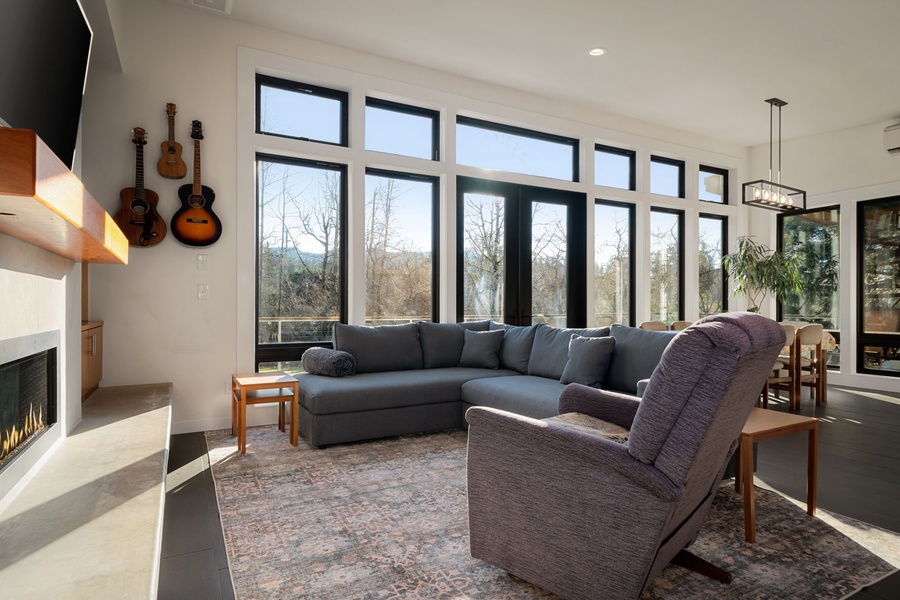 Unwind in this bright living room with panoramic windows, cozy fireplace, and comfortable seating—perfect for relaxing after exploring.