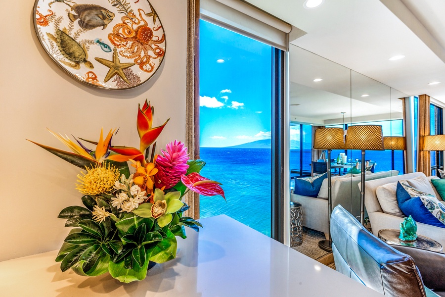 Tropical blooms frame the view as the lanai door opens to endless ocean at Mahana 1119.