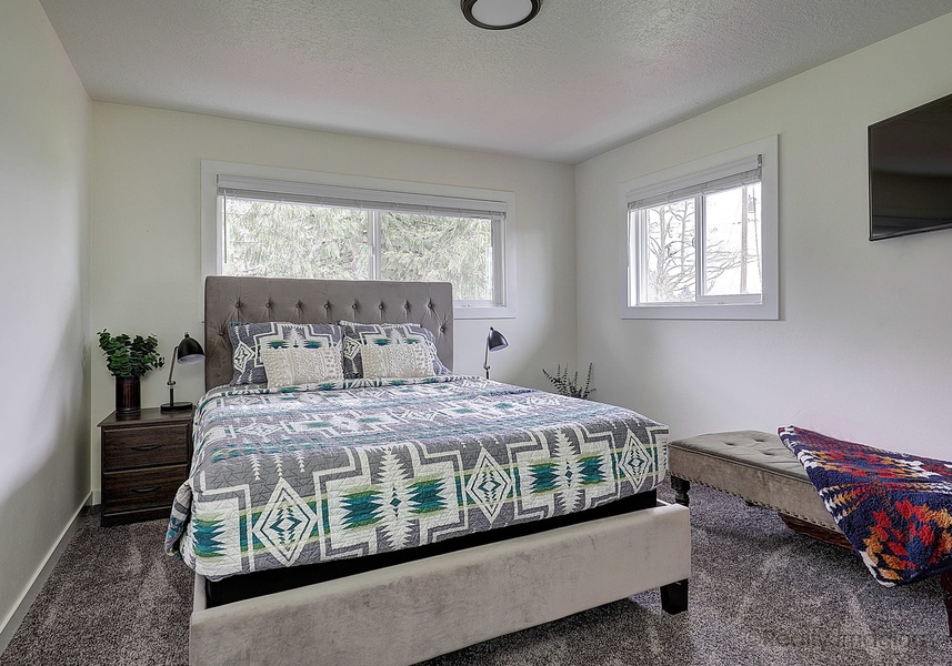 Bedrooms 2 and 3 come with their queen-sized bed, carpeting, and a flat-screen TV, and they share the guest bathroom