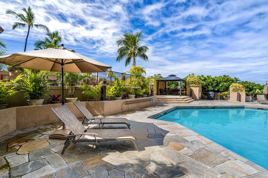 Relaxing poolside with lounge chairs and lush tropical landscaping.