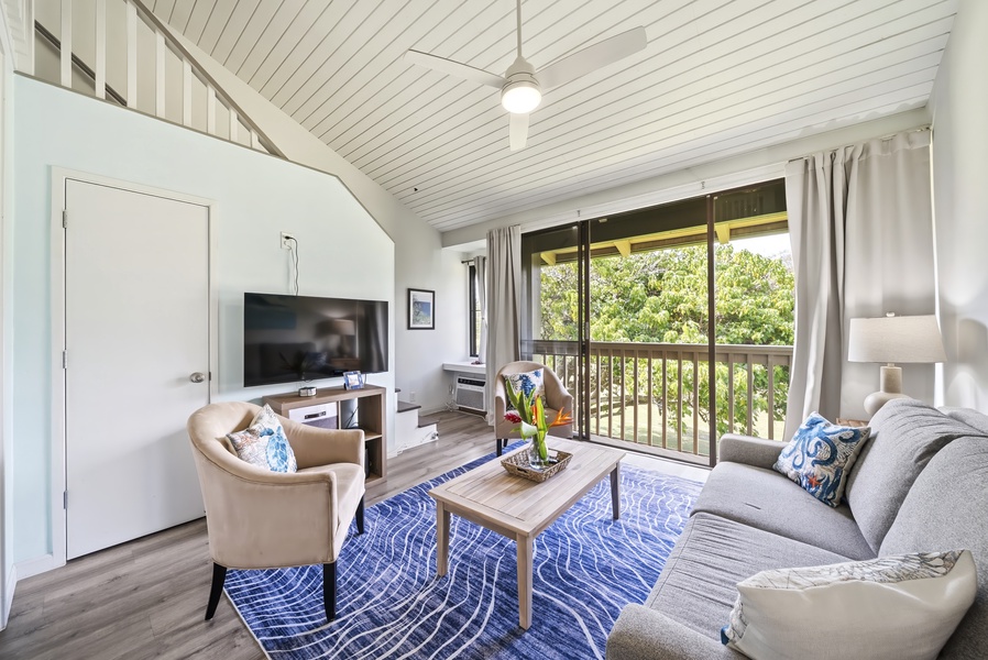 Vaulted ceilings lift the whole living room, with sliding doors framing the green just outside.