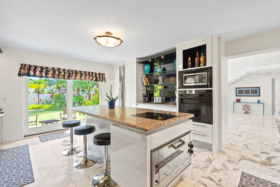 Bright and airy kitchen with an island, bar stools, and a scenic view, creating an ideal space for gathering.