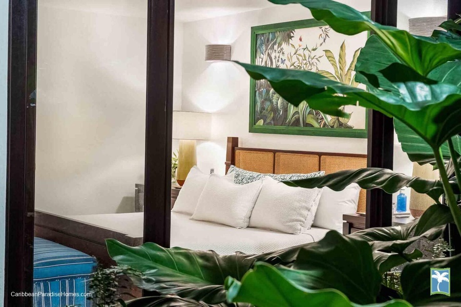 Cozy guest bedroom with access to lush and green foliage.
