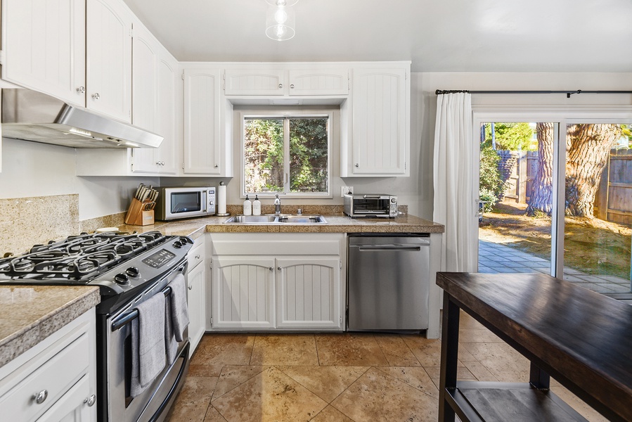 The bright kitchen has direct access to the backyard, making it easy to step outside and dine outdoors.