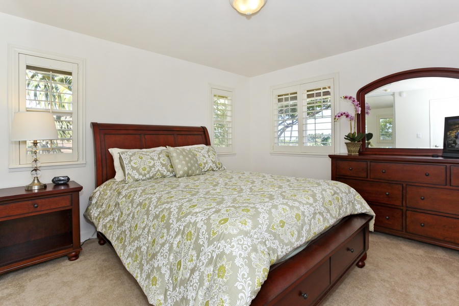 The third guest bedroom featuring soft linens and storage.