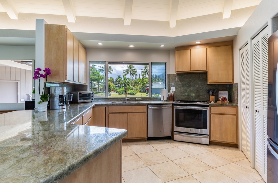 Large, open kitchen with tropical views and stainless steel appliances