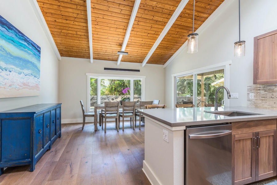Kitchen overlooks dining area with a view of the private pool.