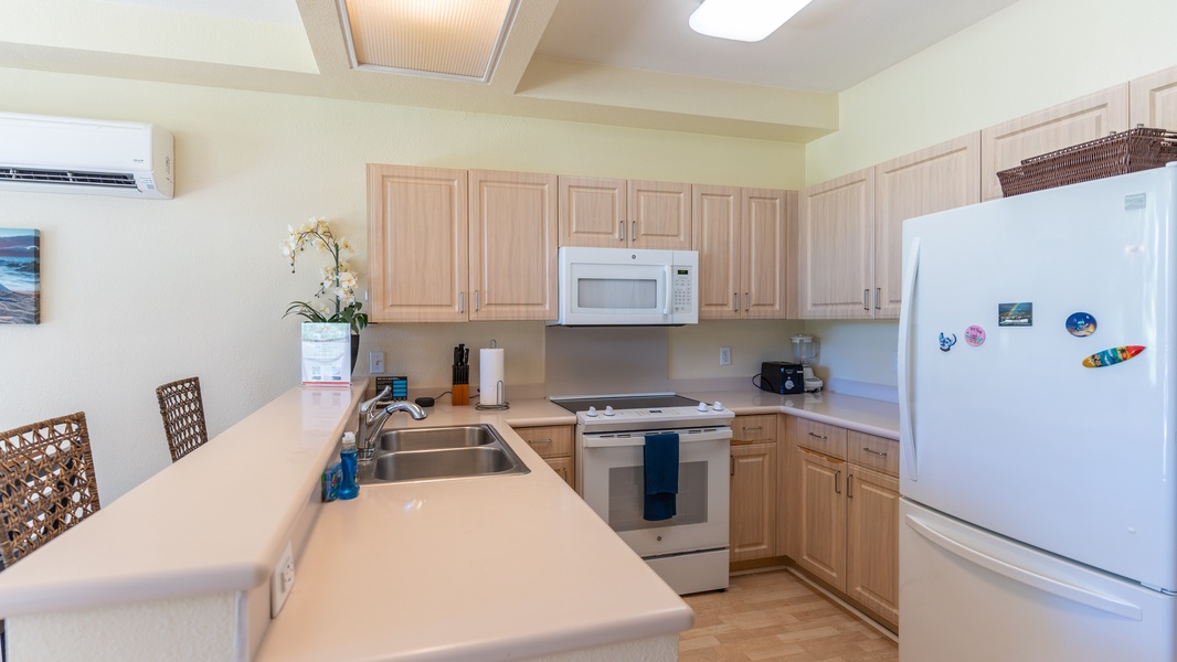 The bright kitchen features a fridge, oven, extended counter-tops and bar seating.