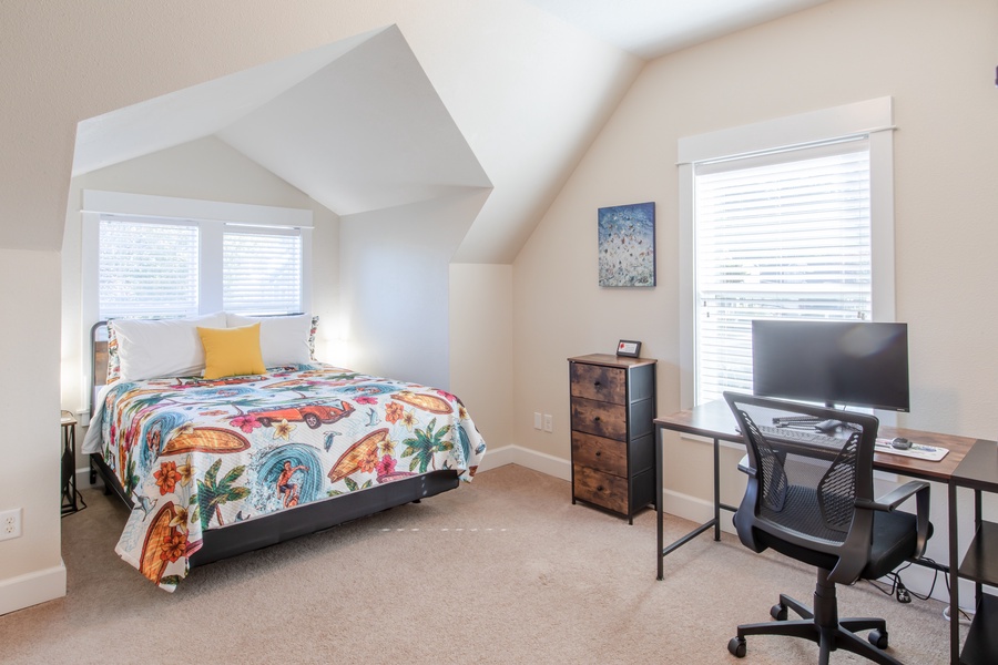 This bedroom also has a convenient dedicated workspace including monitor, keyboard, cable adapters, and mouse with pad