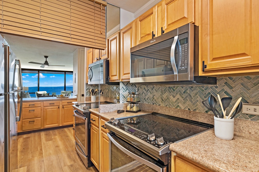 The modern kitchen features stainless steel appliances and a seamless view of the ocean.