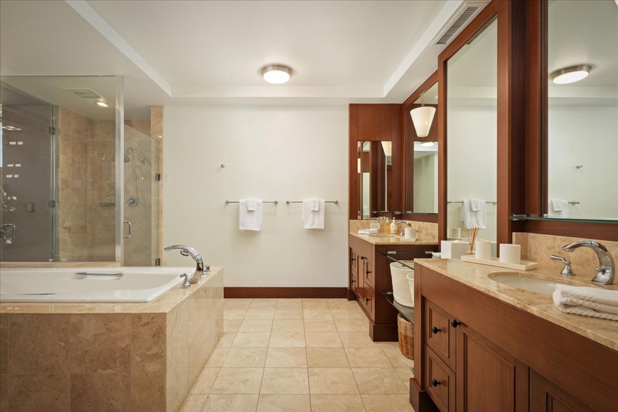 Primary en suite bath with dual vanities, soaking tub, and glass enclosed shower.