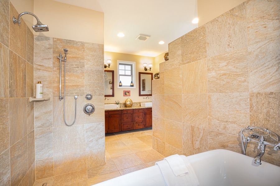 en suite bathroom with a soaking tub, large walk-in shower, and dual vanities.